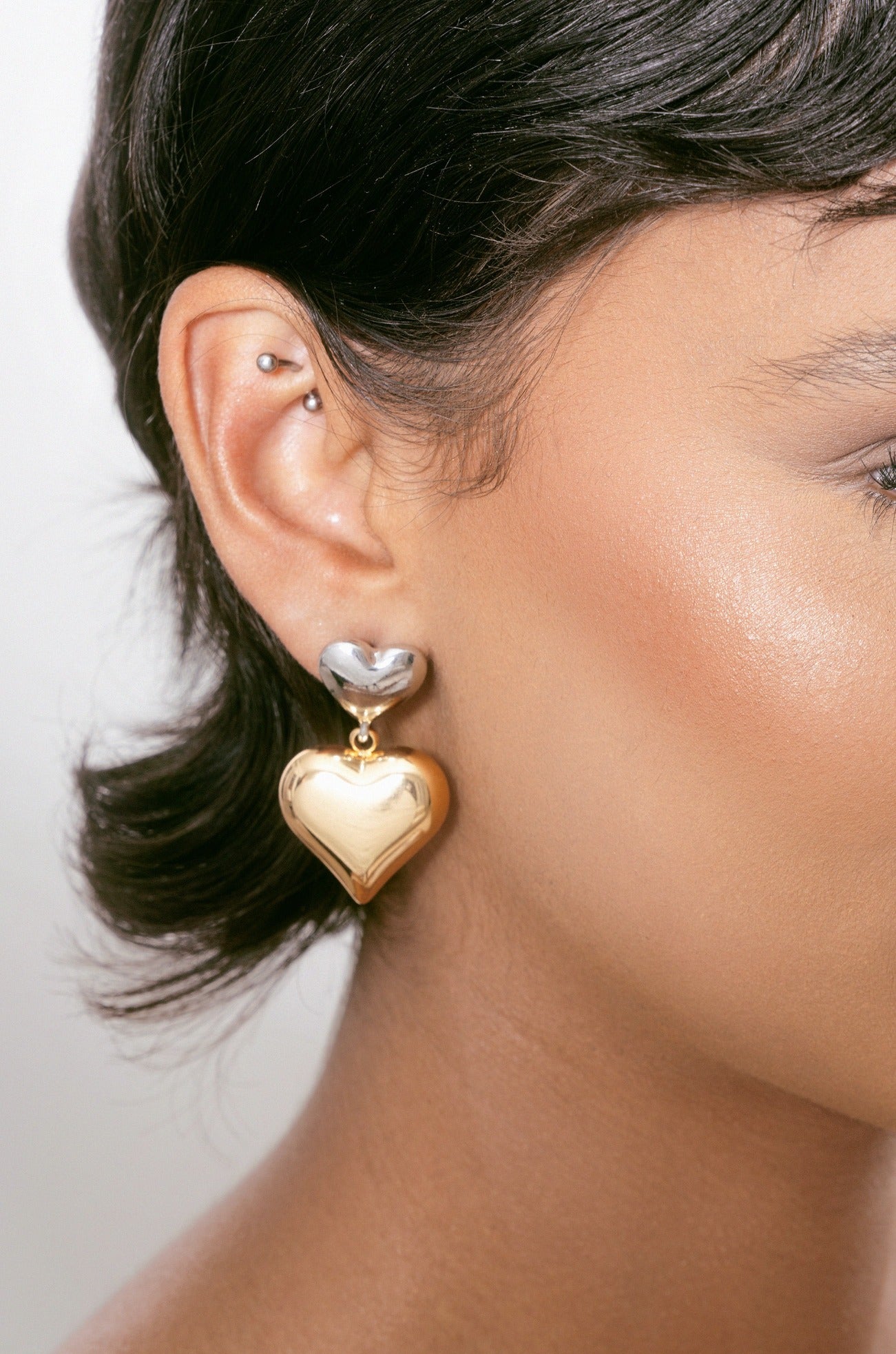 Dangling Mixed Metal Heart Earrings on model