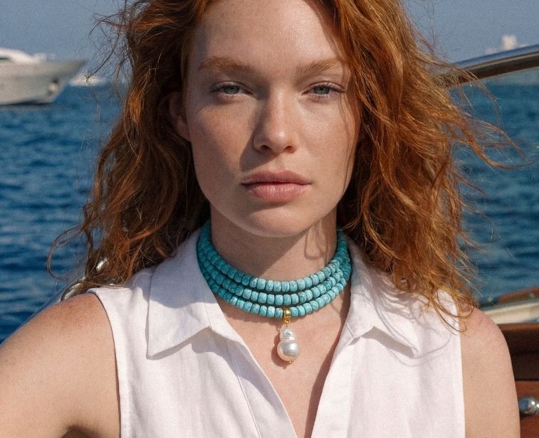 turquoise beaded necklace on a model on a boat
