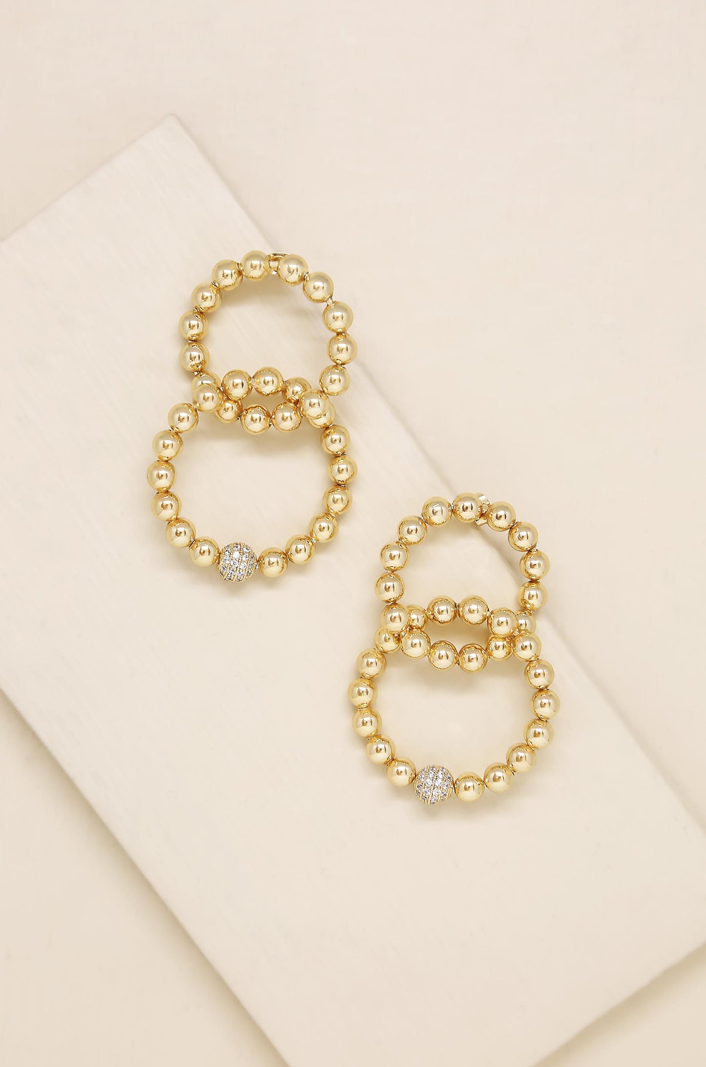Interlocked 18k Gold Plated Ball Dangle Earrings on slate background