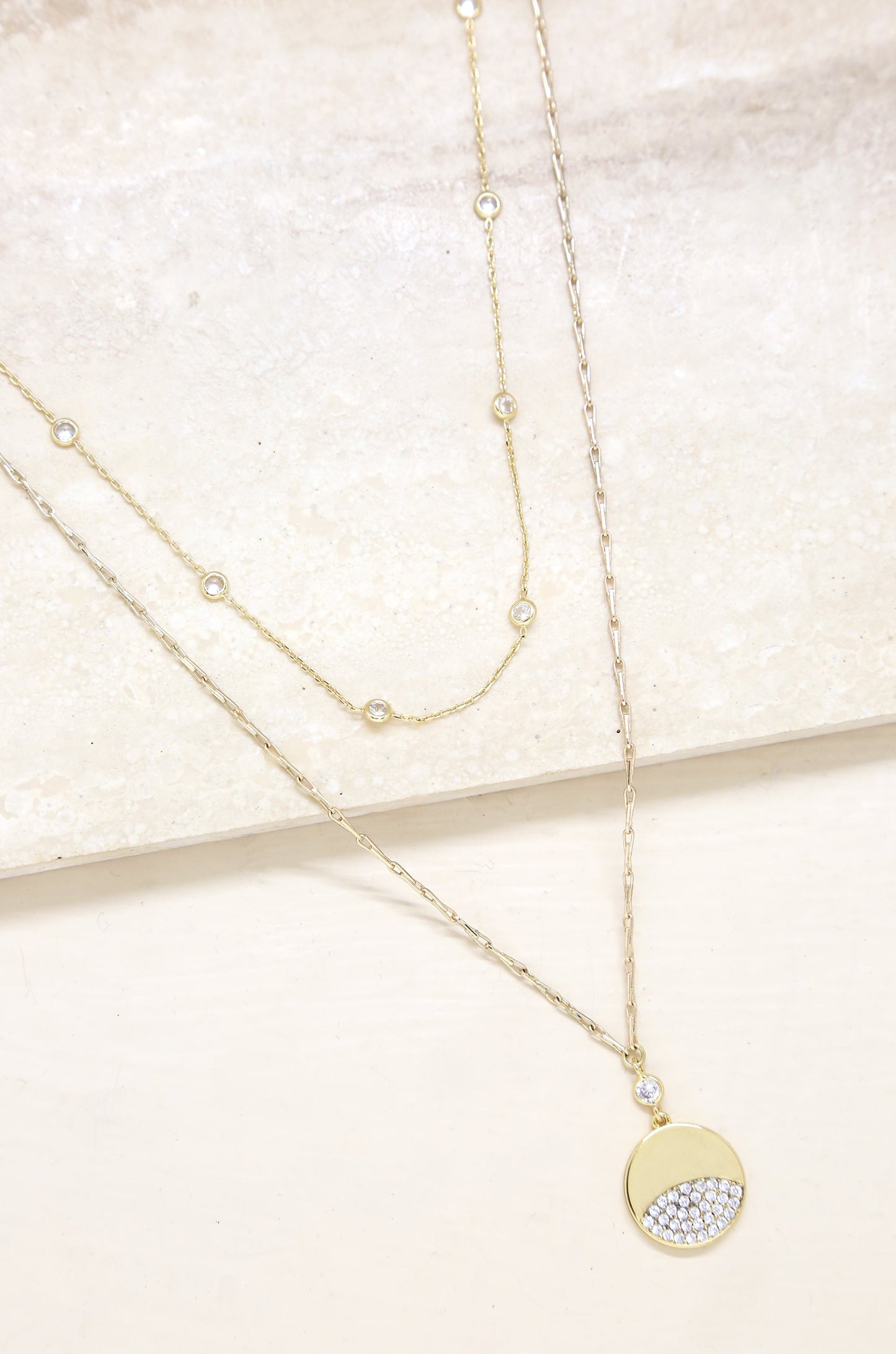 Crystal Dipped Layered Pendant Necklace Set on slate background
