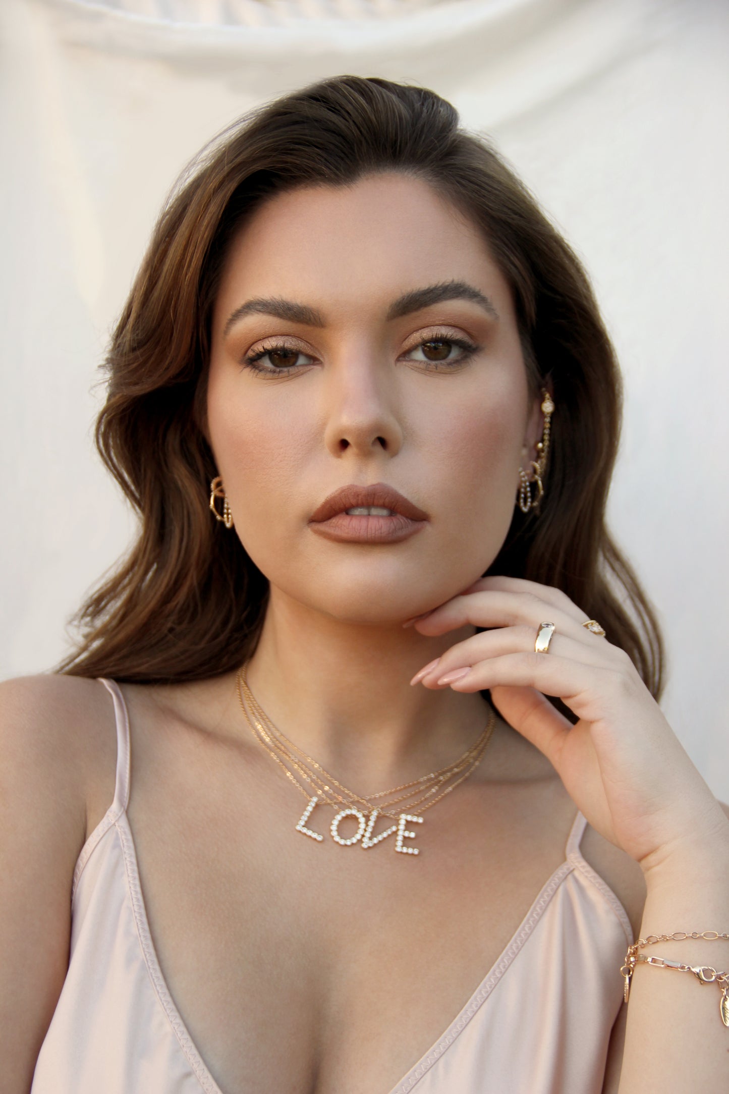 Letters L O V E Simple Crystal Initial Necklaces shown on a model