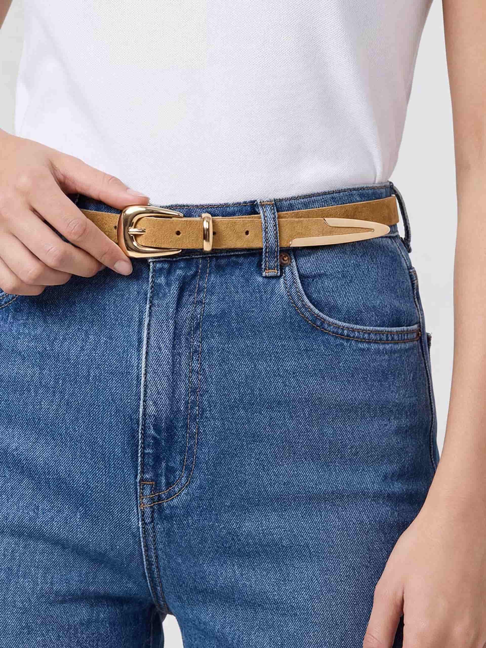 Model wearing tan leather belt with gold buckle, styled with white shirt and blue jeans.