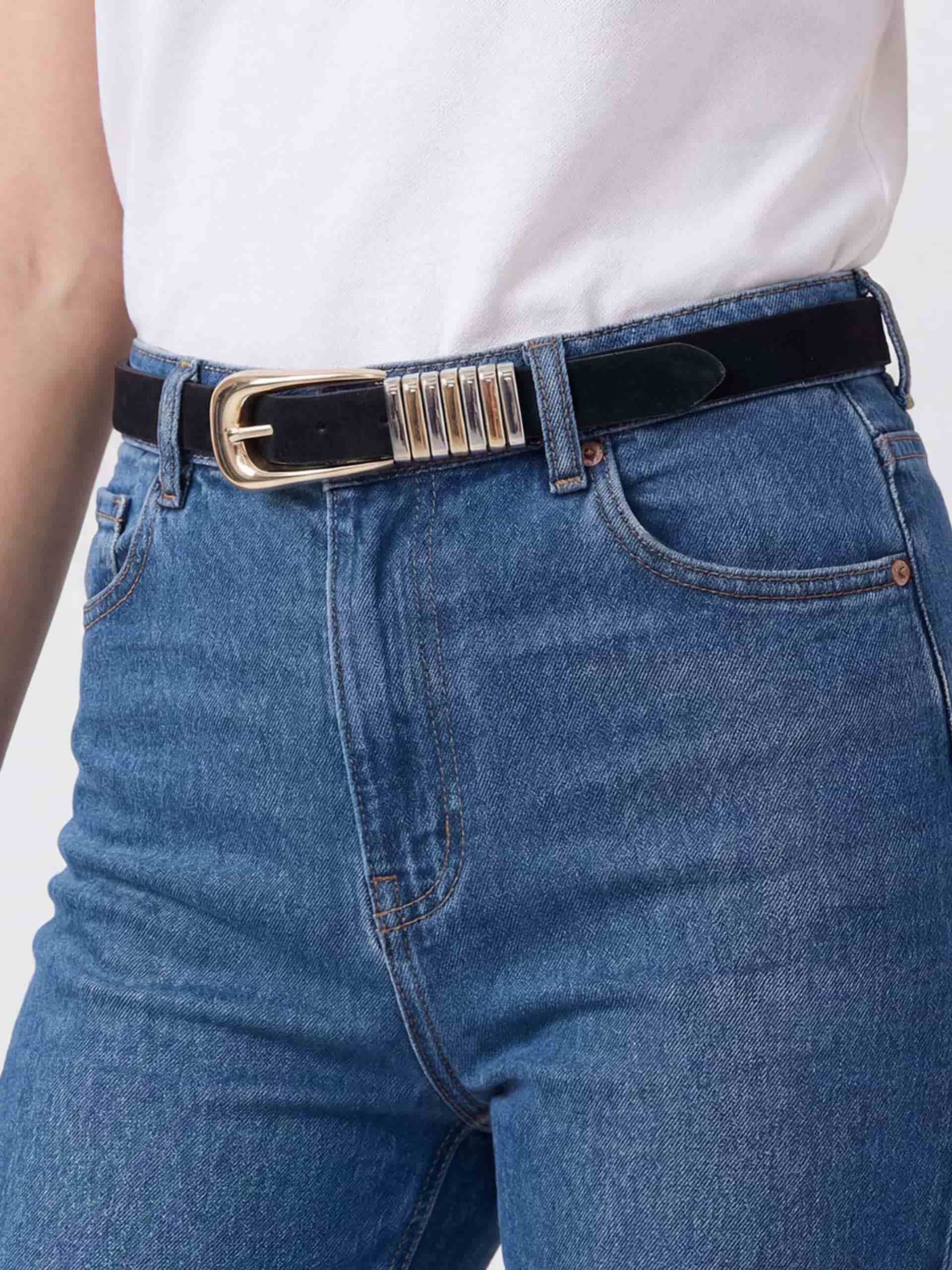 Black suede belt with gold buckle styled with denim jeans.