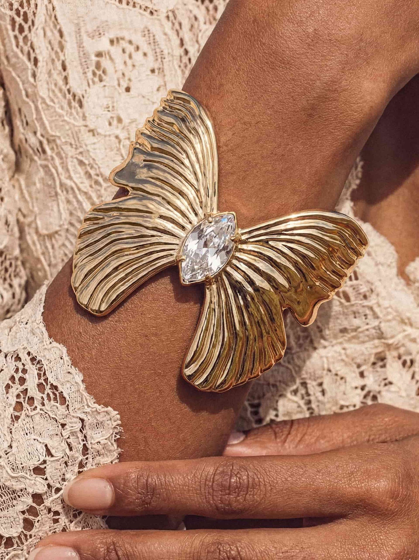Gold butterfly statement cuff close-up on warm skin