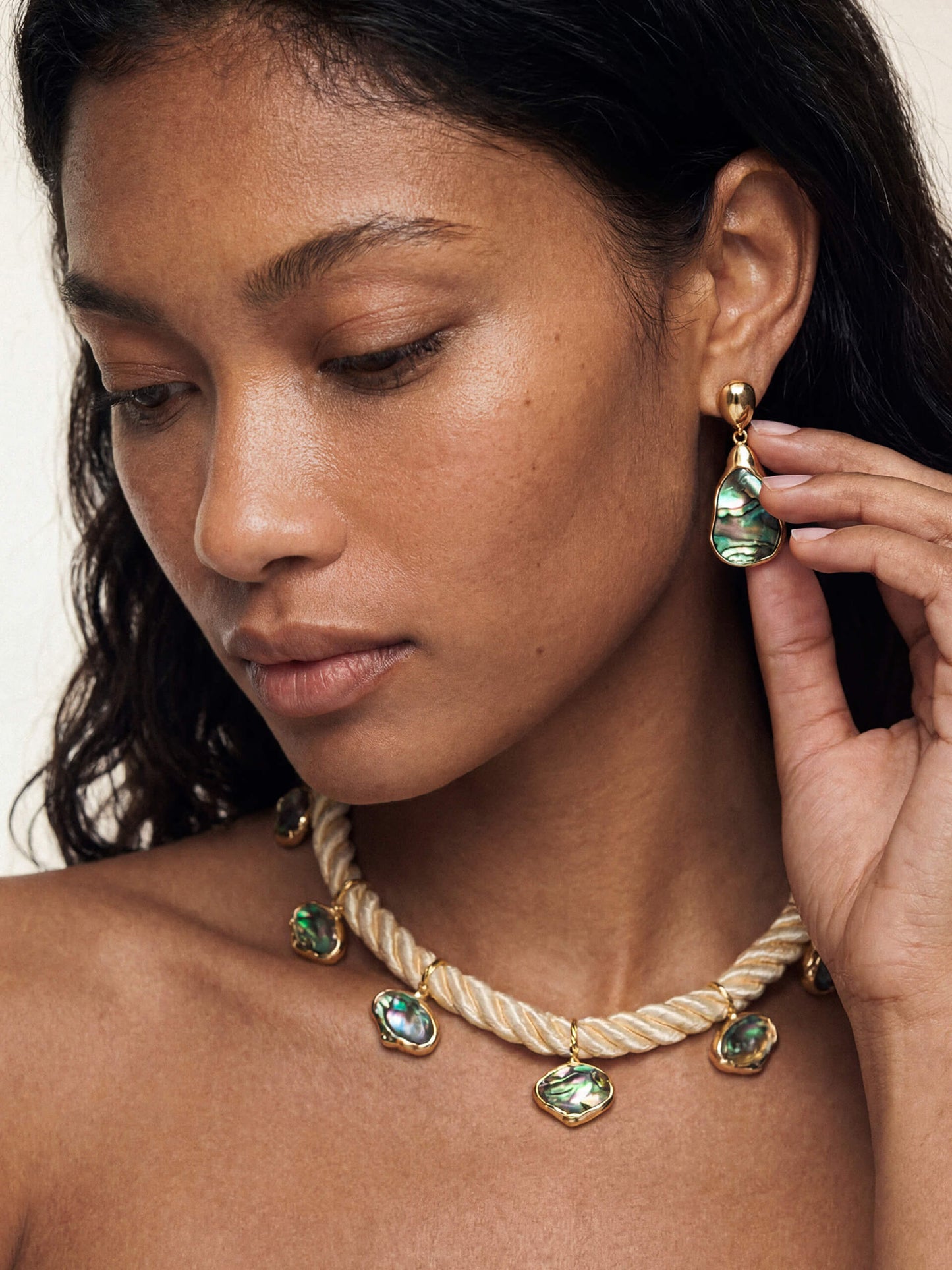 Model with wearing abalone-shell earrings and a matching necklace on a rope chain