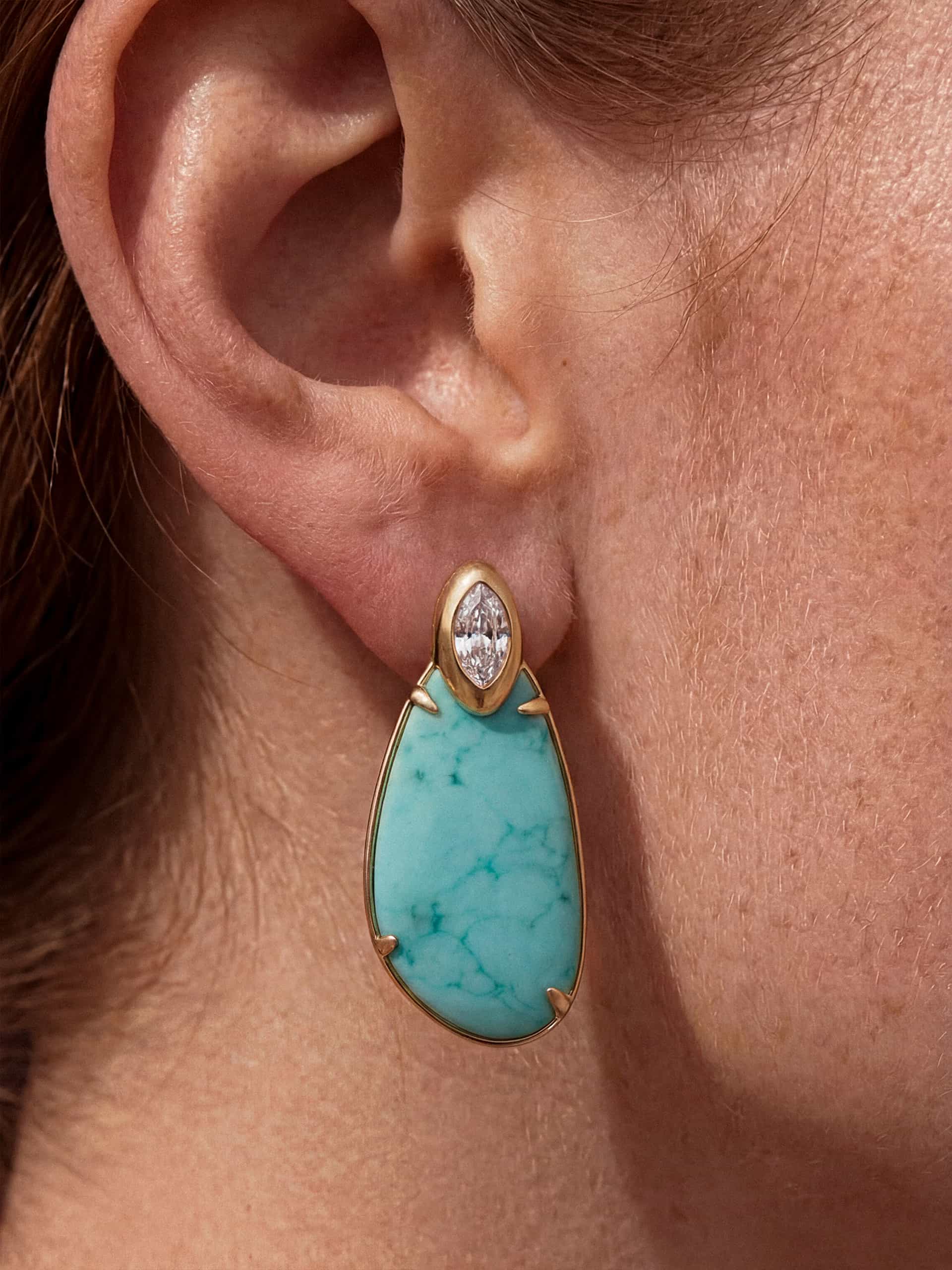 Turquoise drop earring on ear