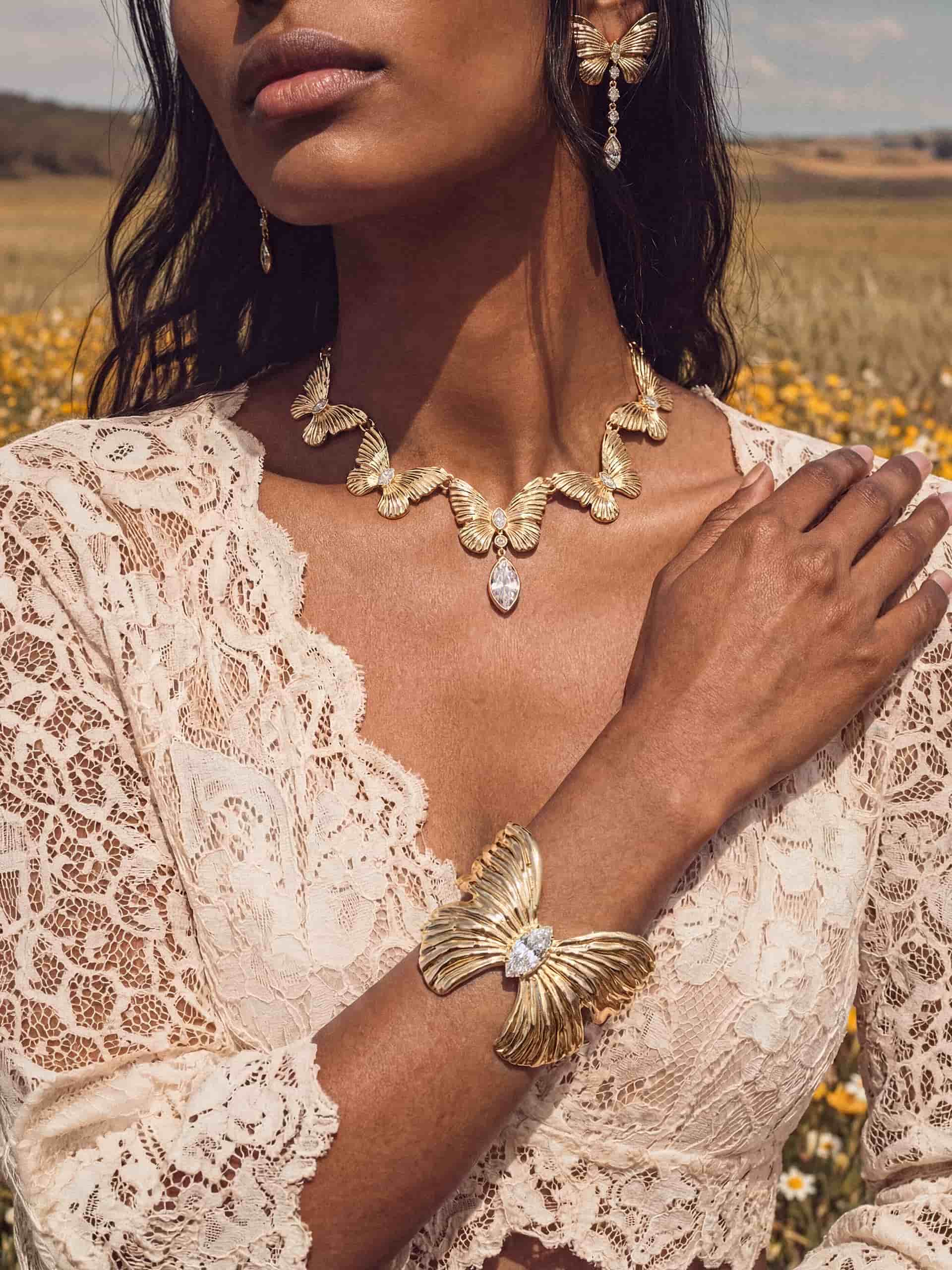 Woman in white lace, gold butterfly necklace and bracelet