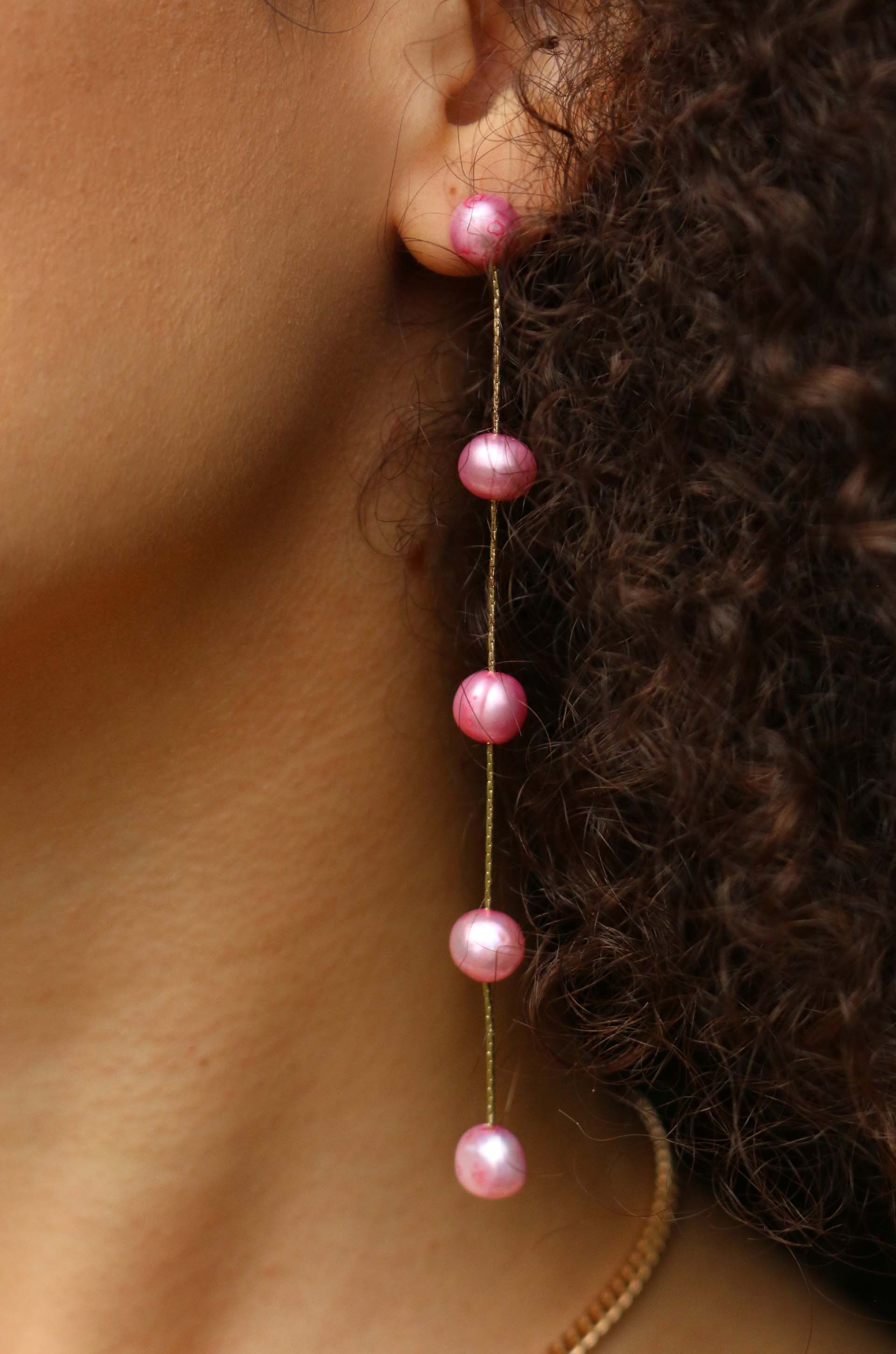 Dripping Pearl Delicate Drop Earrings in pink on a model