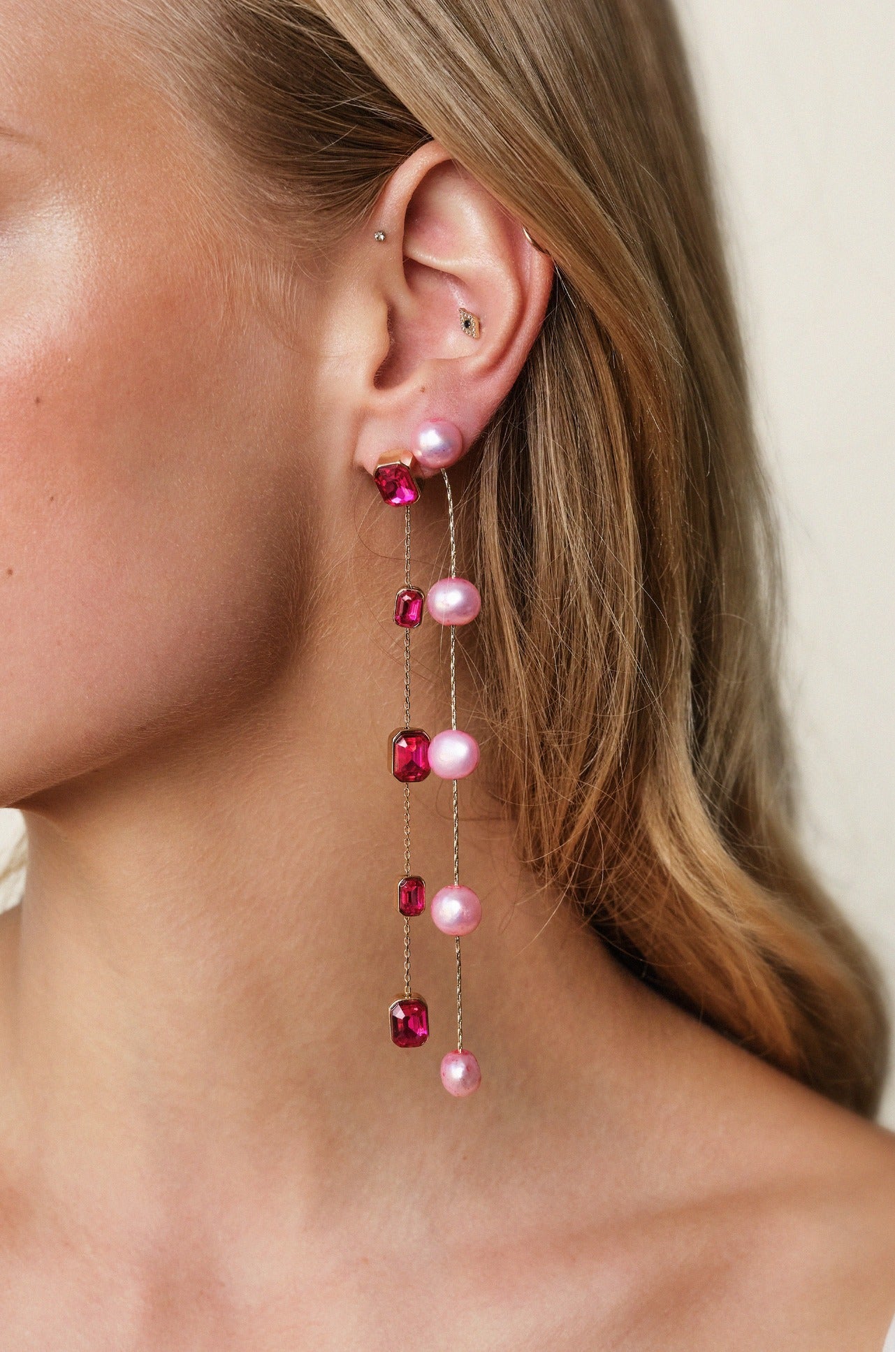 Iconic Crystal Dangle Earrings in fuschia on model