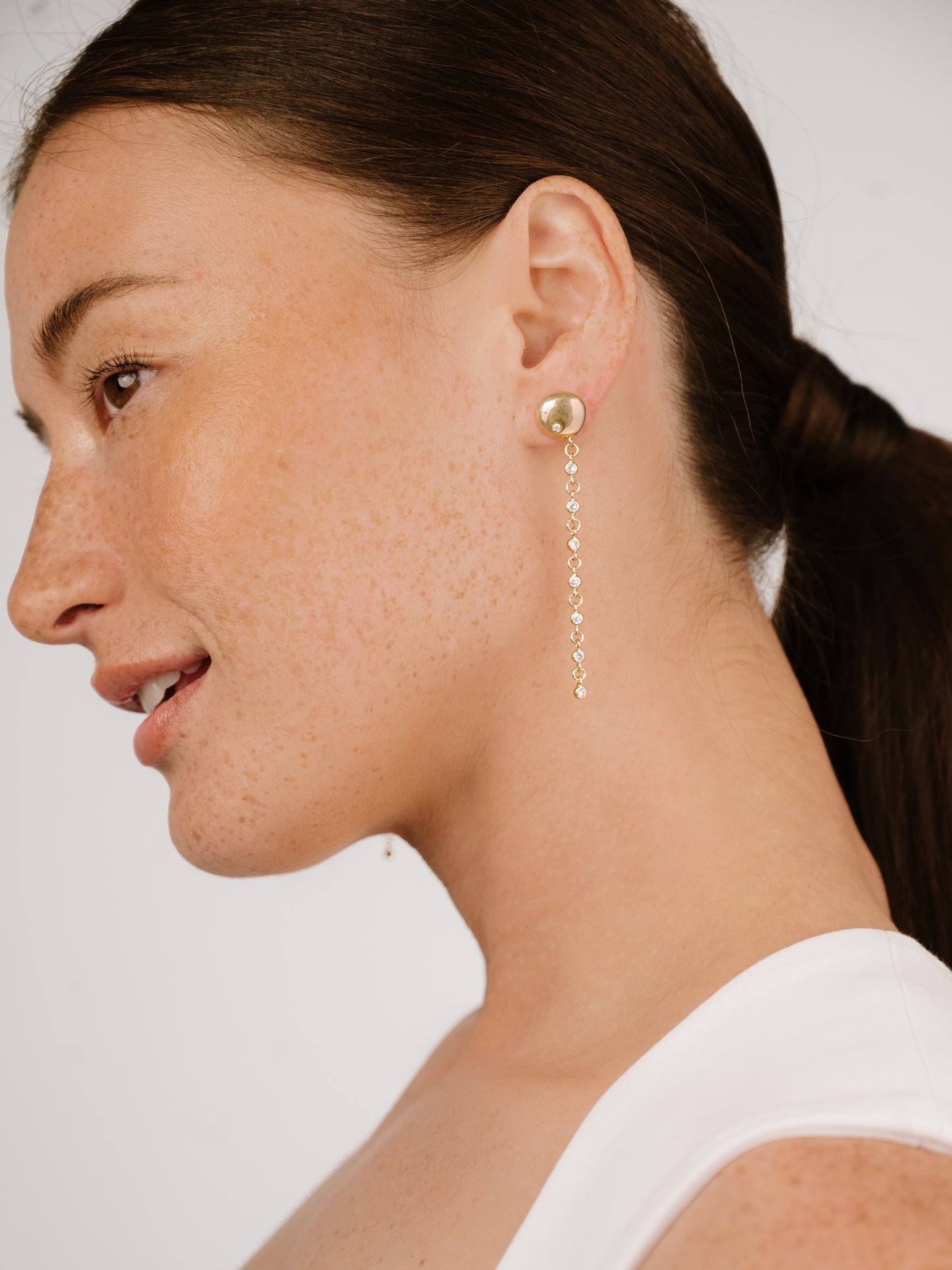 Polished Pebble Linear Crystal Chain Drop Earrings on model 3