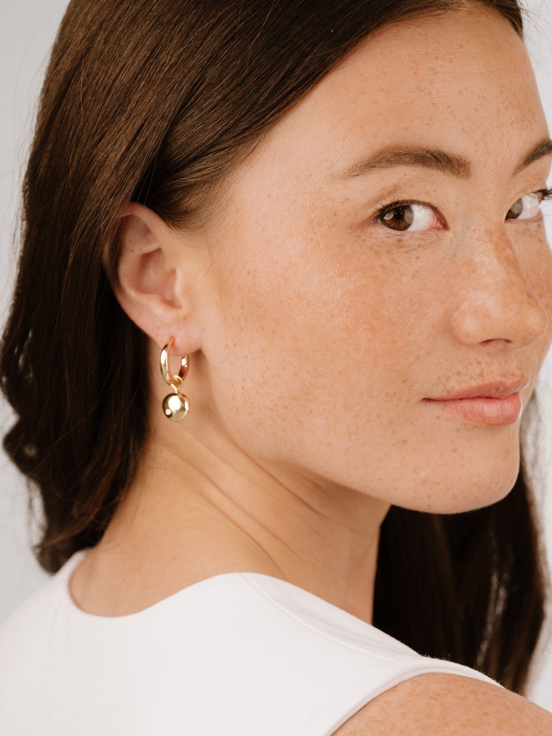 Polished Pebble Huggie Hoop Earrings on model 5