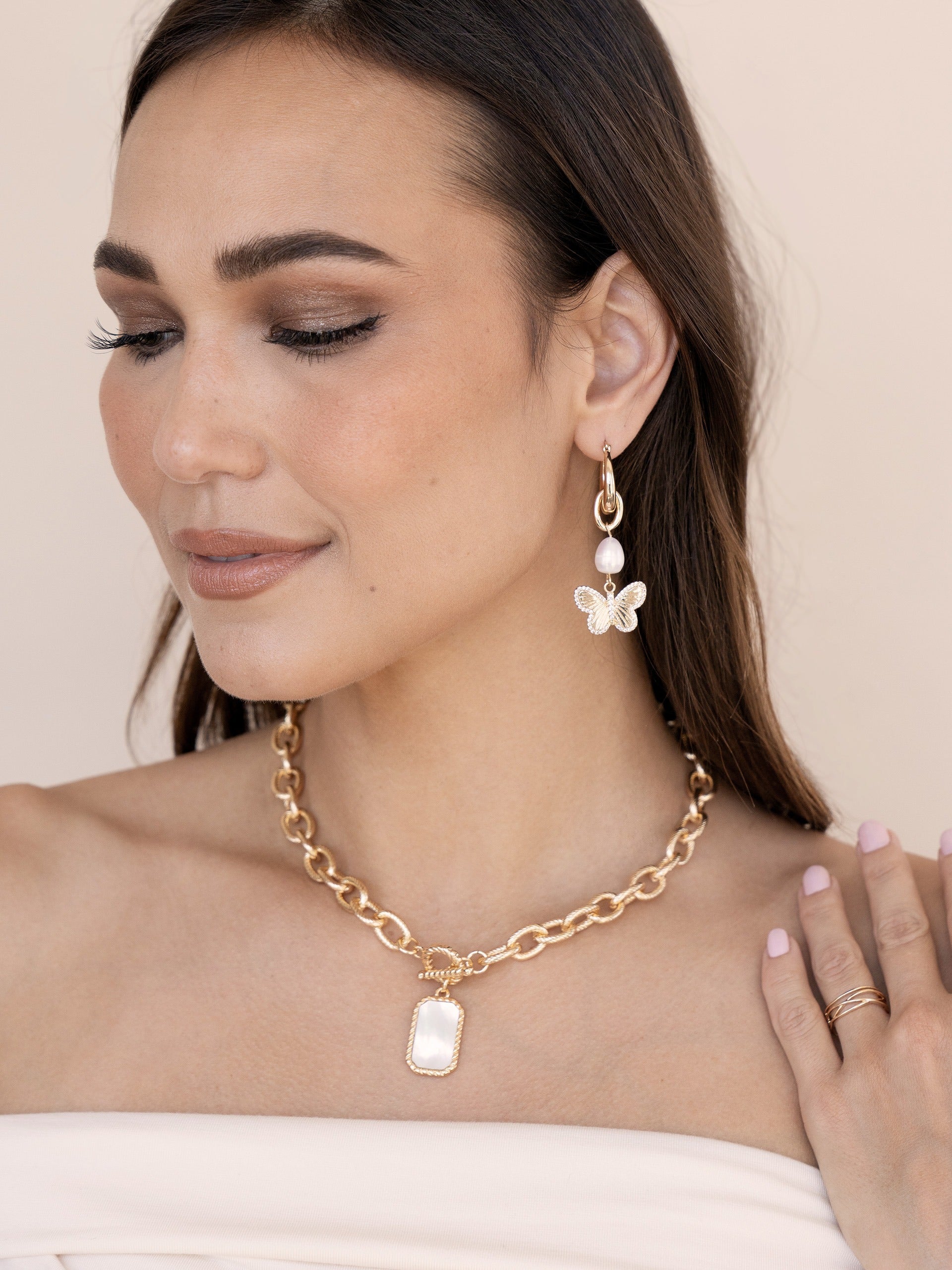 Butterfly High Pearl Drop Earrings on model 2