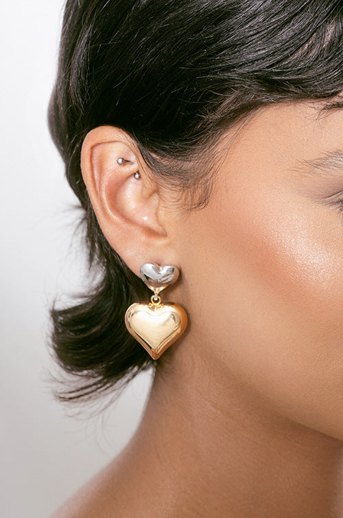 model in mixed metal heart earrings
