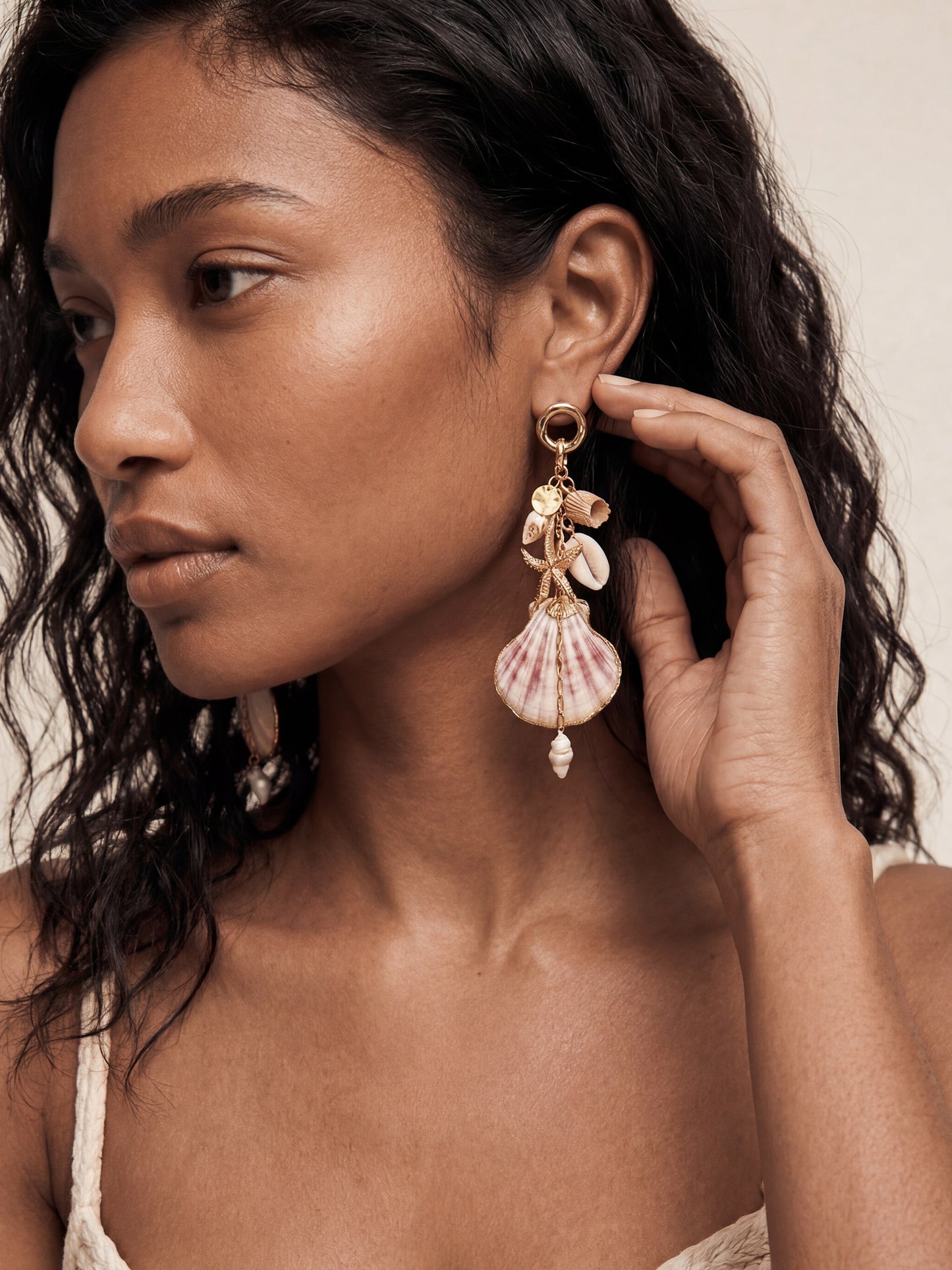 Woman wears Mermaid Tears seashell earrings