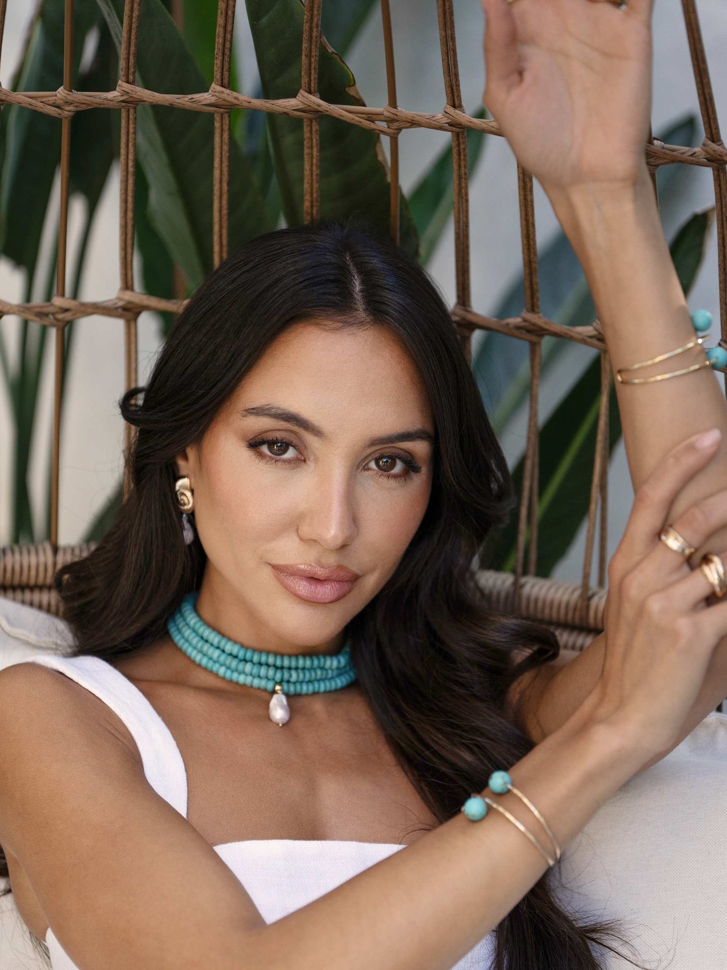 model in wicker chair wearing turquoise jewelry