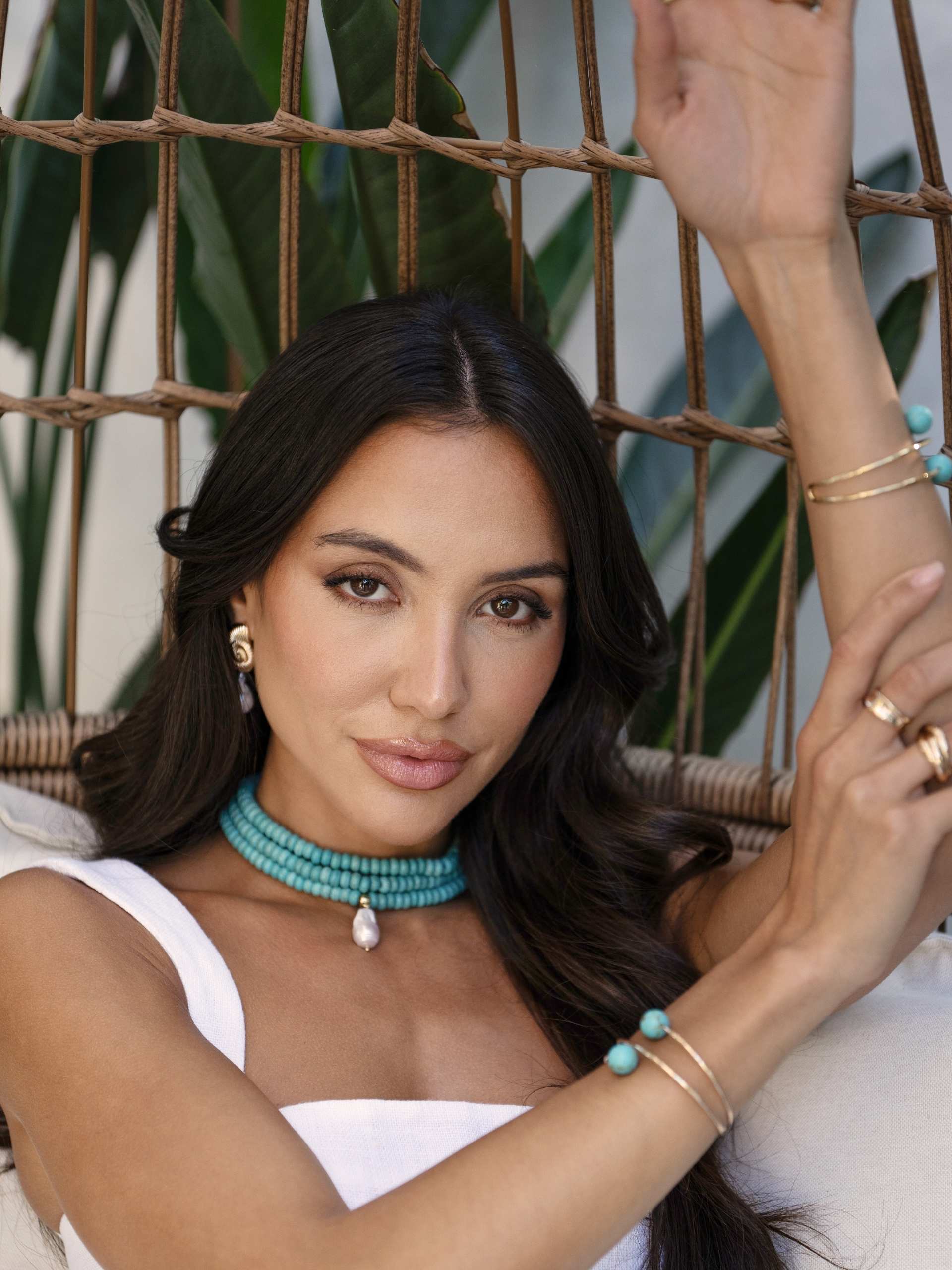 model in wicker chair wearing turquoise jewelry