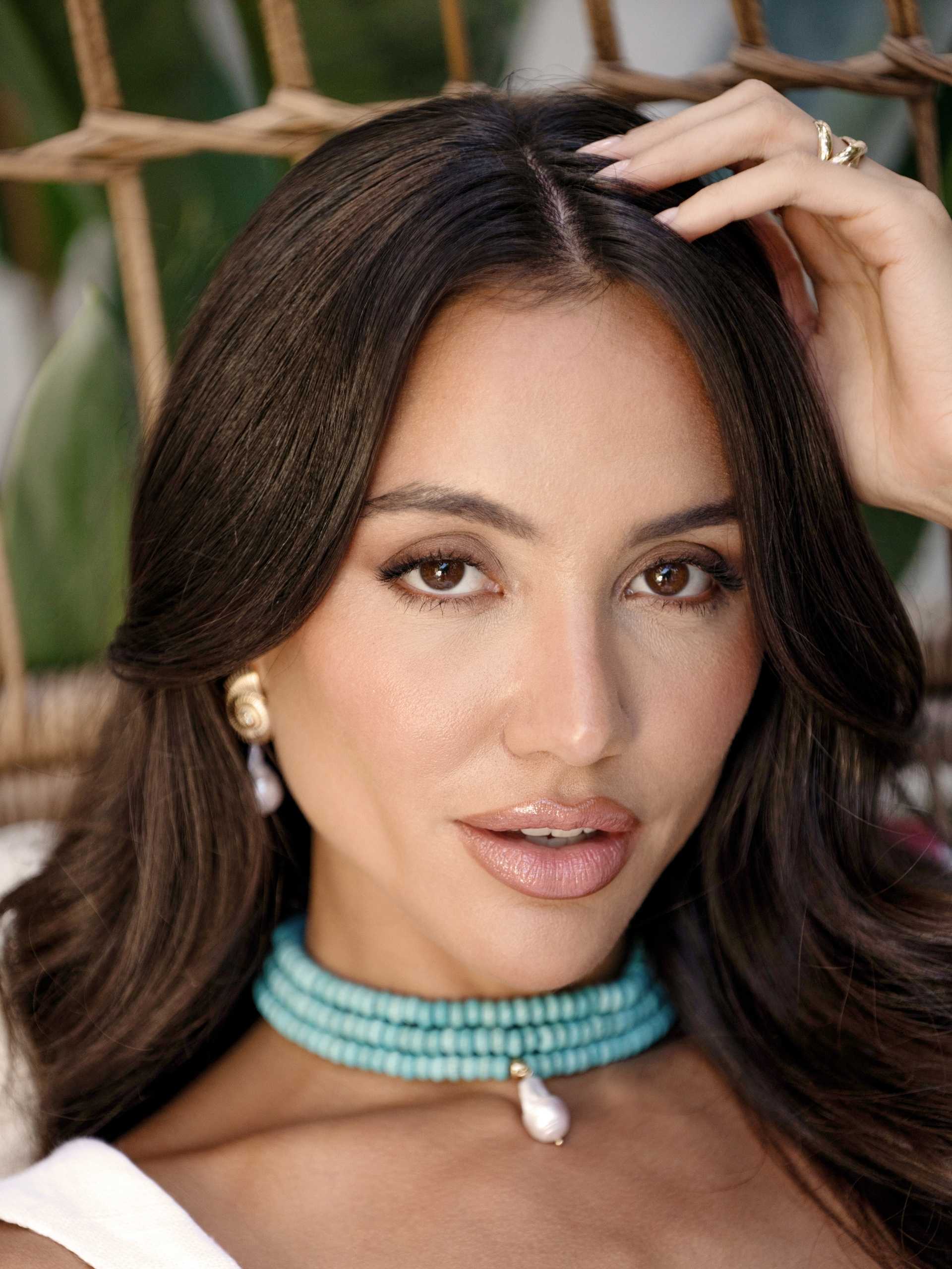 Woman wearing a turquoise beaded necklace with a blurred background
