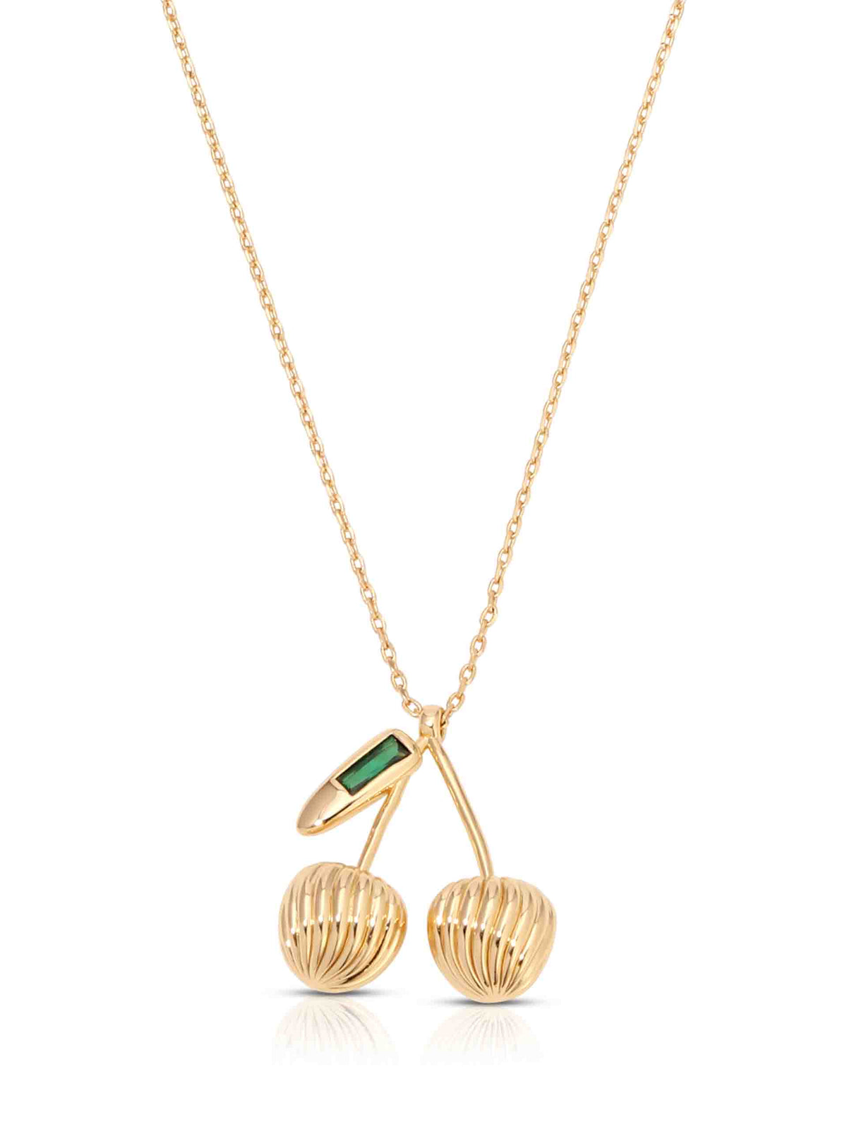 A delicate gold-tone necklace with a long fine chain and two textured round charms, joined by a small green leaf; elegant, playful jewelry on white.