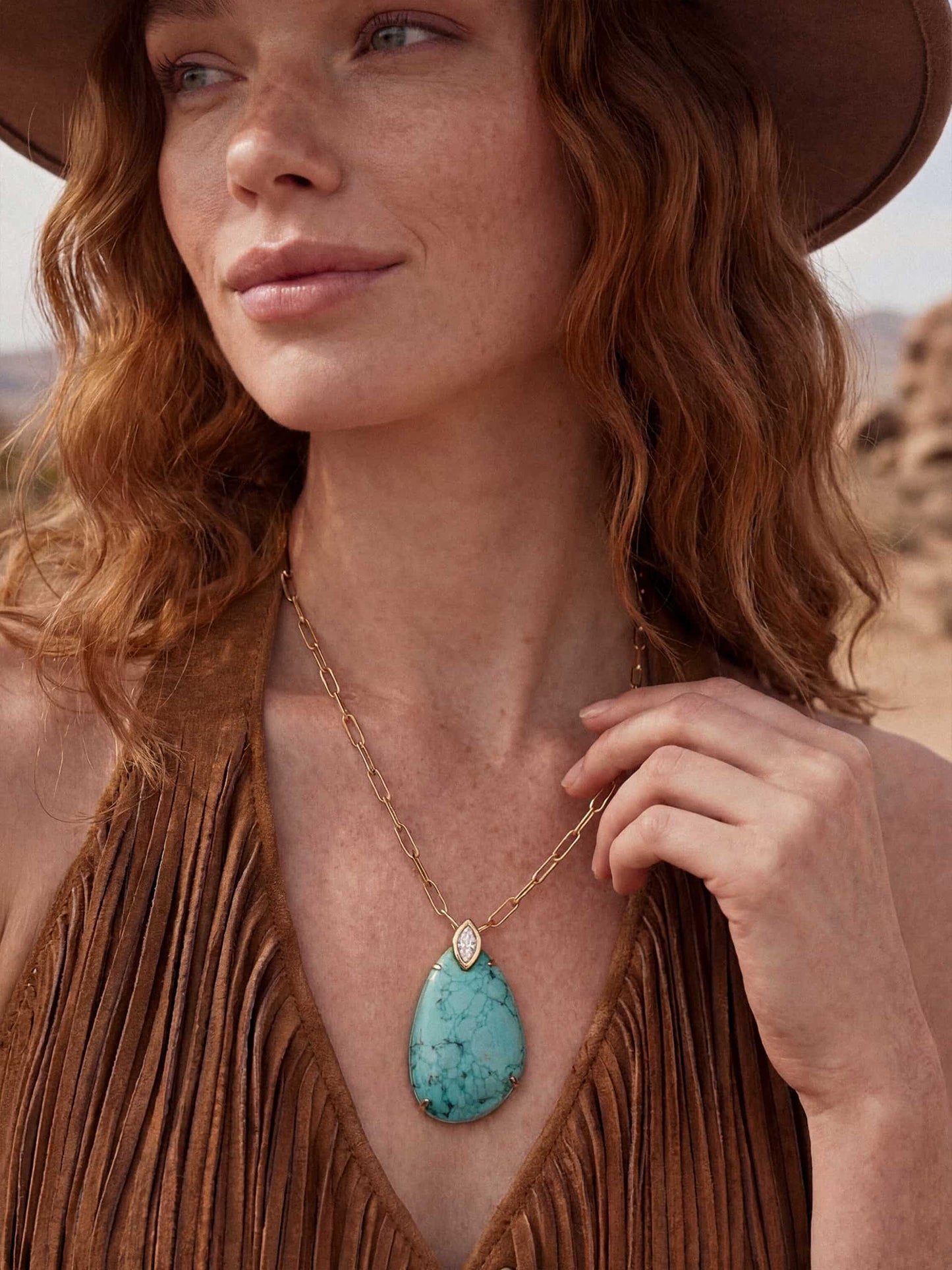 Model wearing turquoise pendant necklace and hat