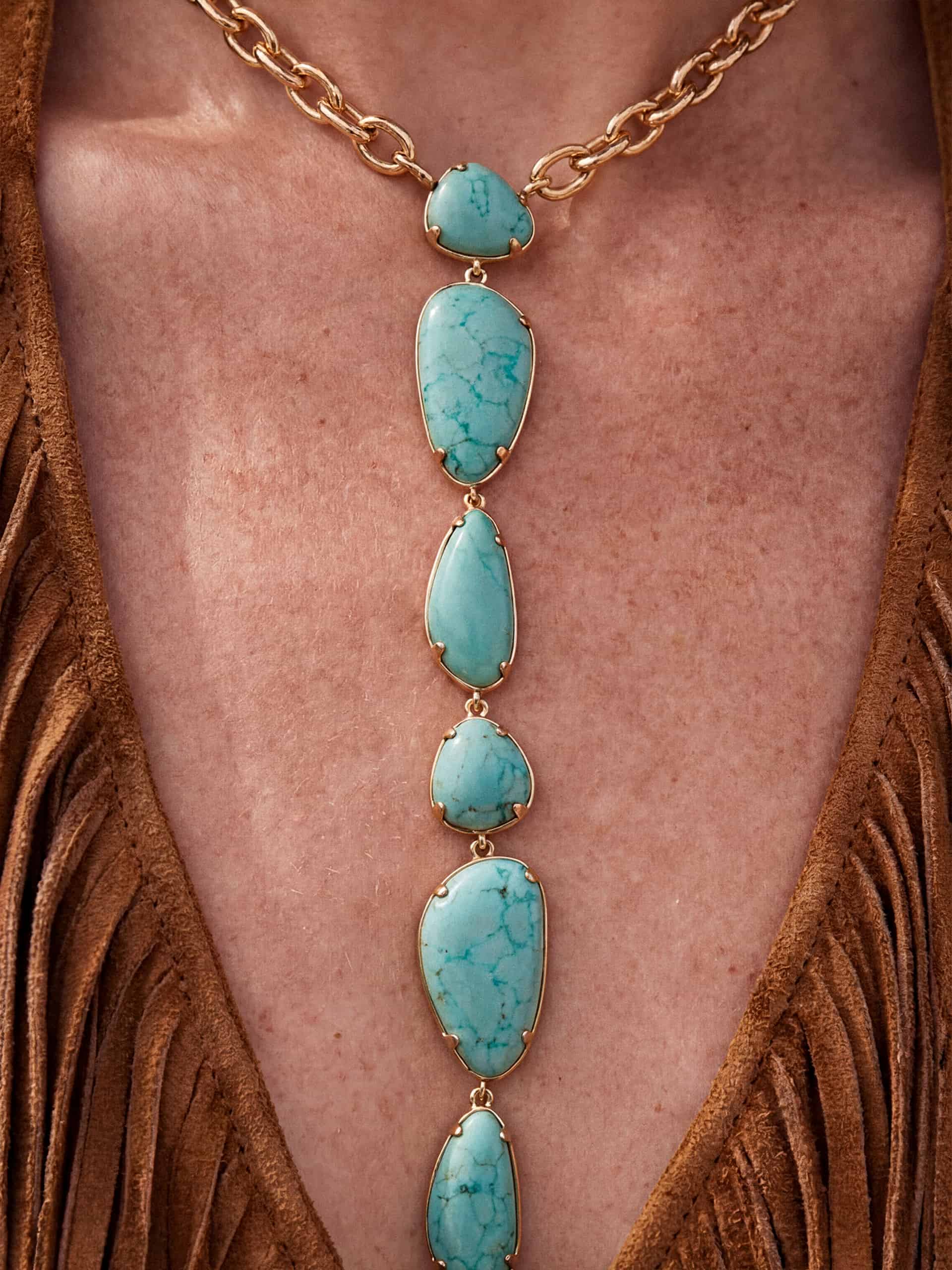 View of long turquoise statement necklace on chest