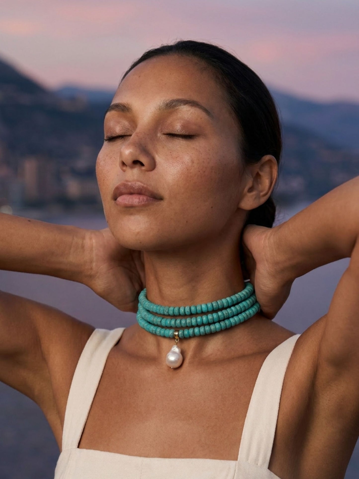 model with closed eye wearing three layer beaded necklace