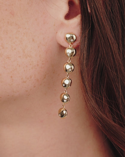 Polished Pebble Linear Dangle Earrings in gold on model in video