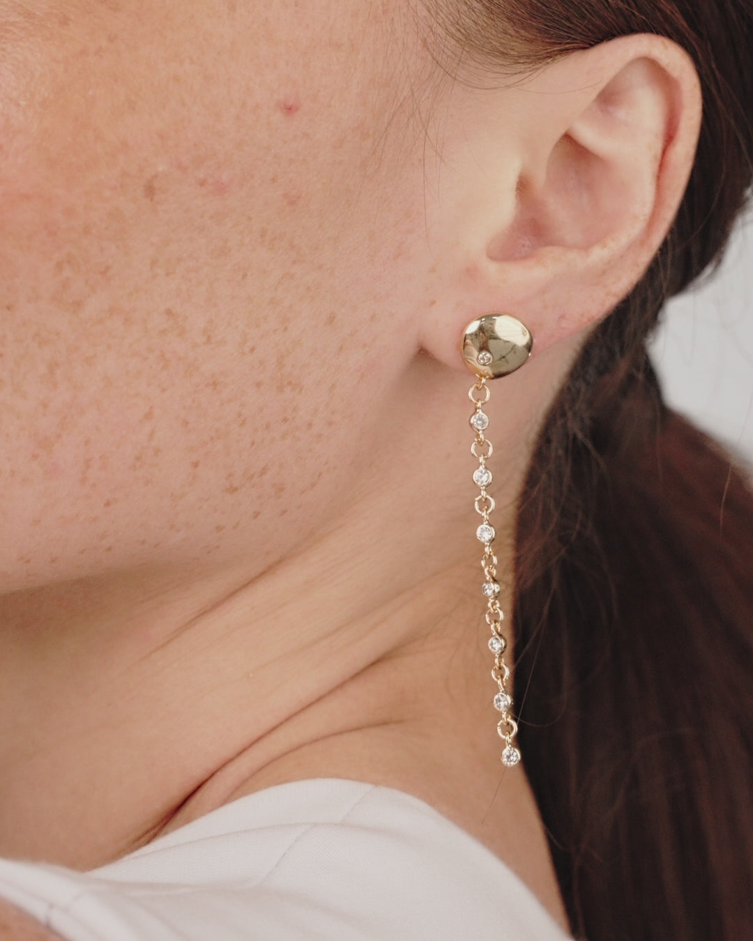 Polished Pebble Linear Crystal Chain Drop Earrings in gold on model in video