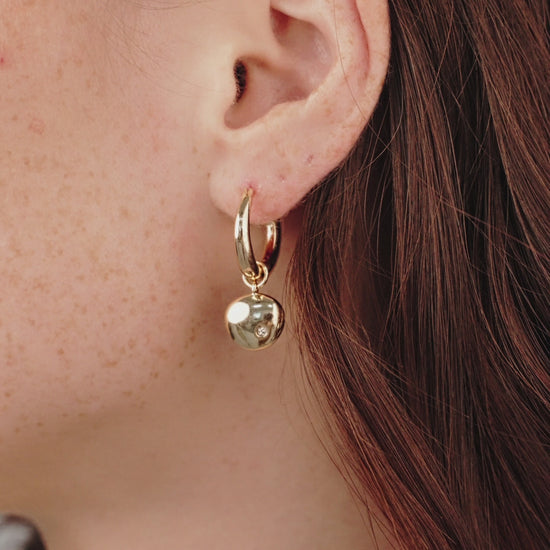 Polished Pebble Huggie Hoop Earrings in gold on model in video