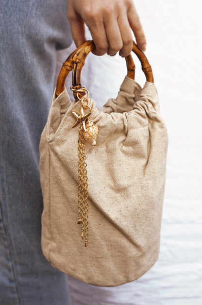 Beige Bucket Bag with Starfish & Shell Tassel shown on a model