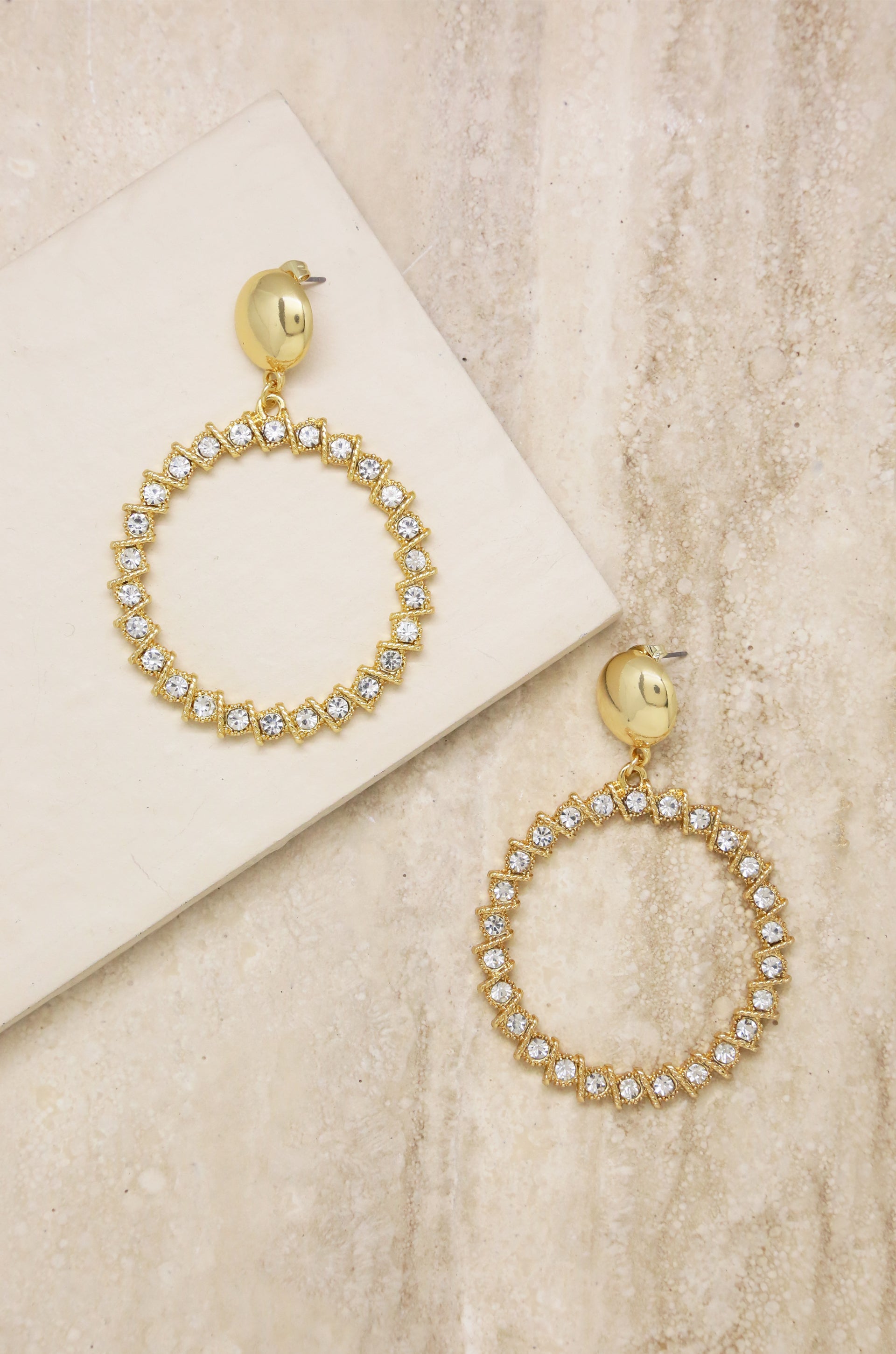 Cyclical Crystal Drop 18k Gold Plated Earrings on slate background  