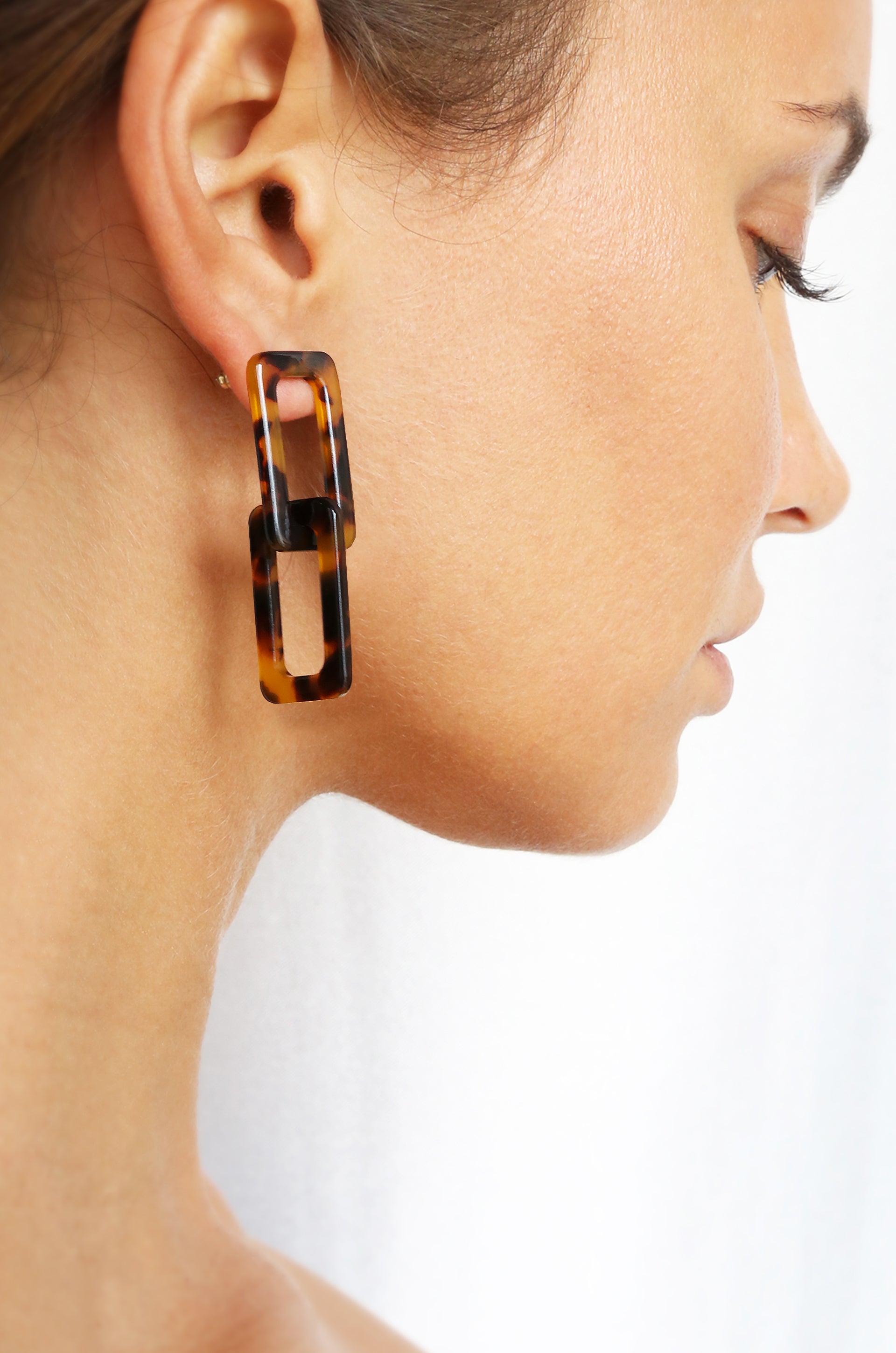 Interlocking Tortoise Resin Rectangle Earrings  shown on a model  
