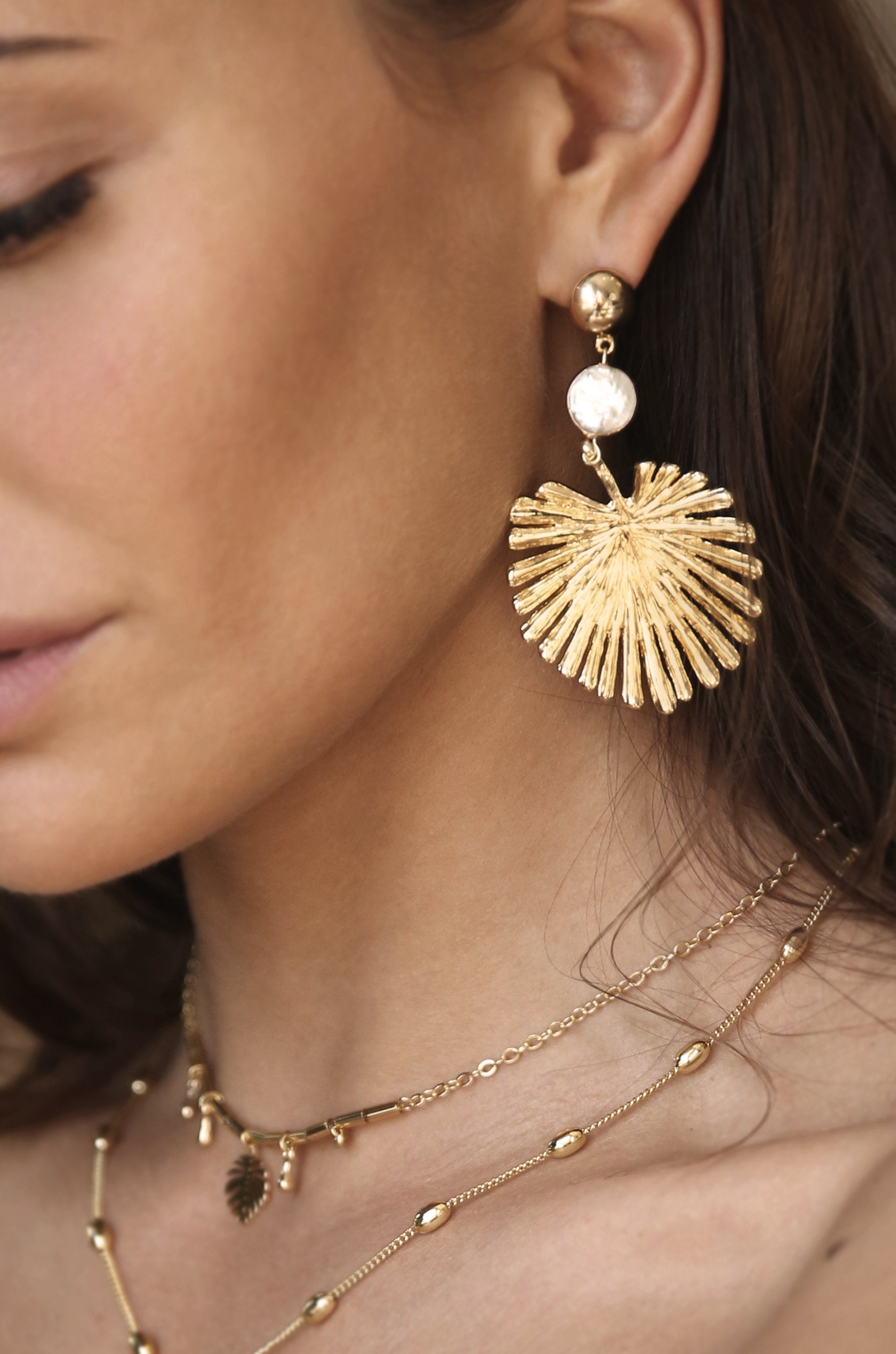 Palm Leaf Earring with Pearl in Gold shown on a model  