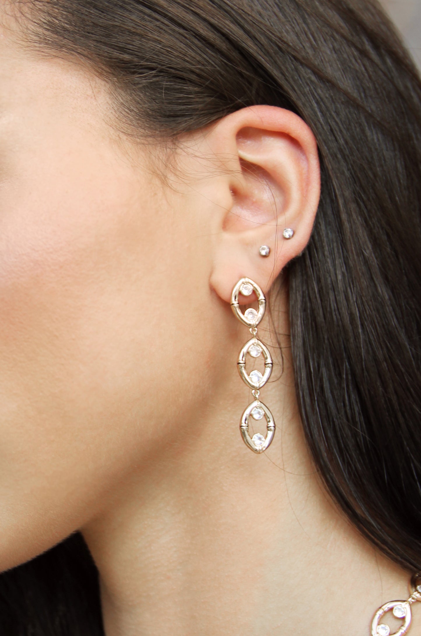 Crystal & 18k Gold Plated Bamboo Eyelet Drop Earrings shown on a model  