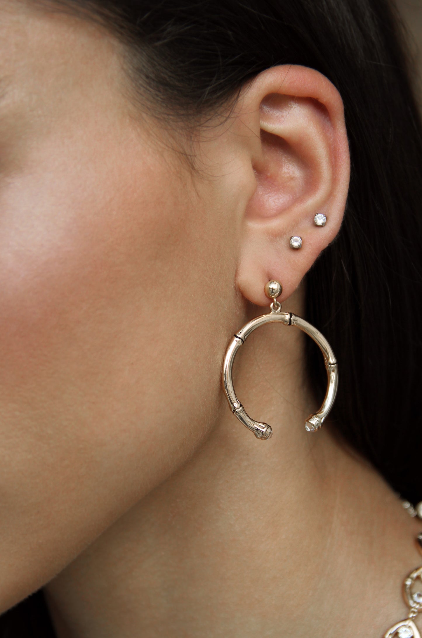 Wishful Thinking 18k Gold Plated Bamboo Earrings shown on a model  