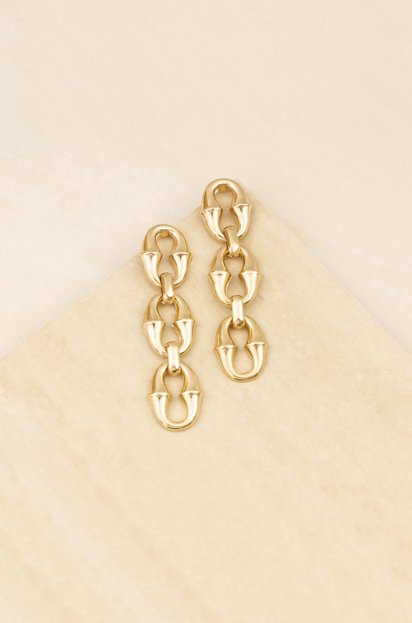Triple Link Drop 18k Gold Plated Earrings on slate background