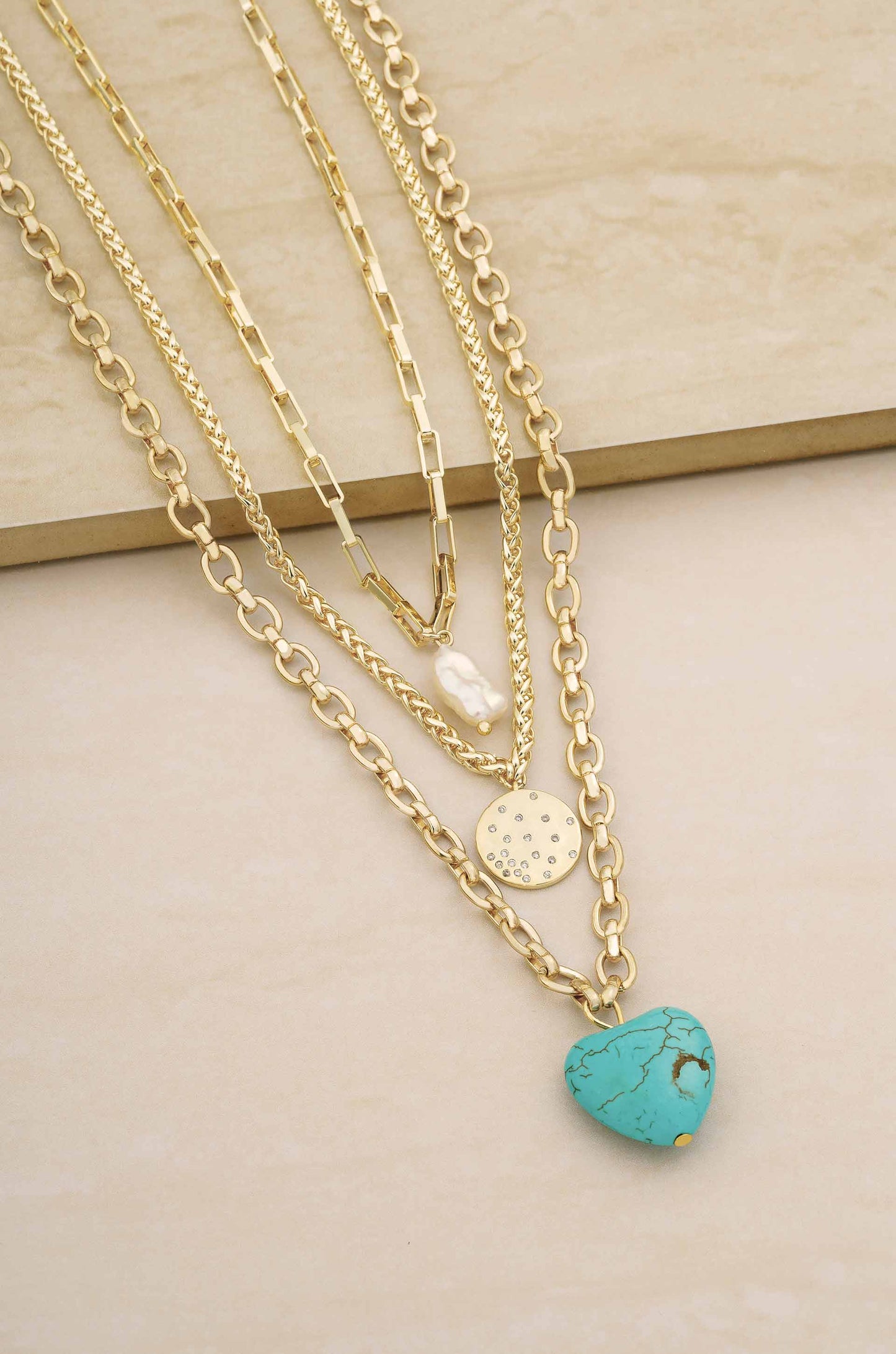 The Malibu Turquoise, Coin, and Pearl 18k Gold Plated Necklace Set on slate