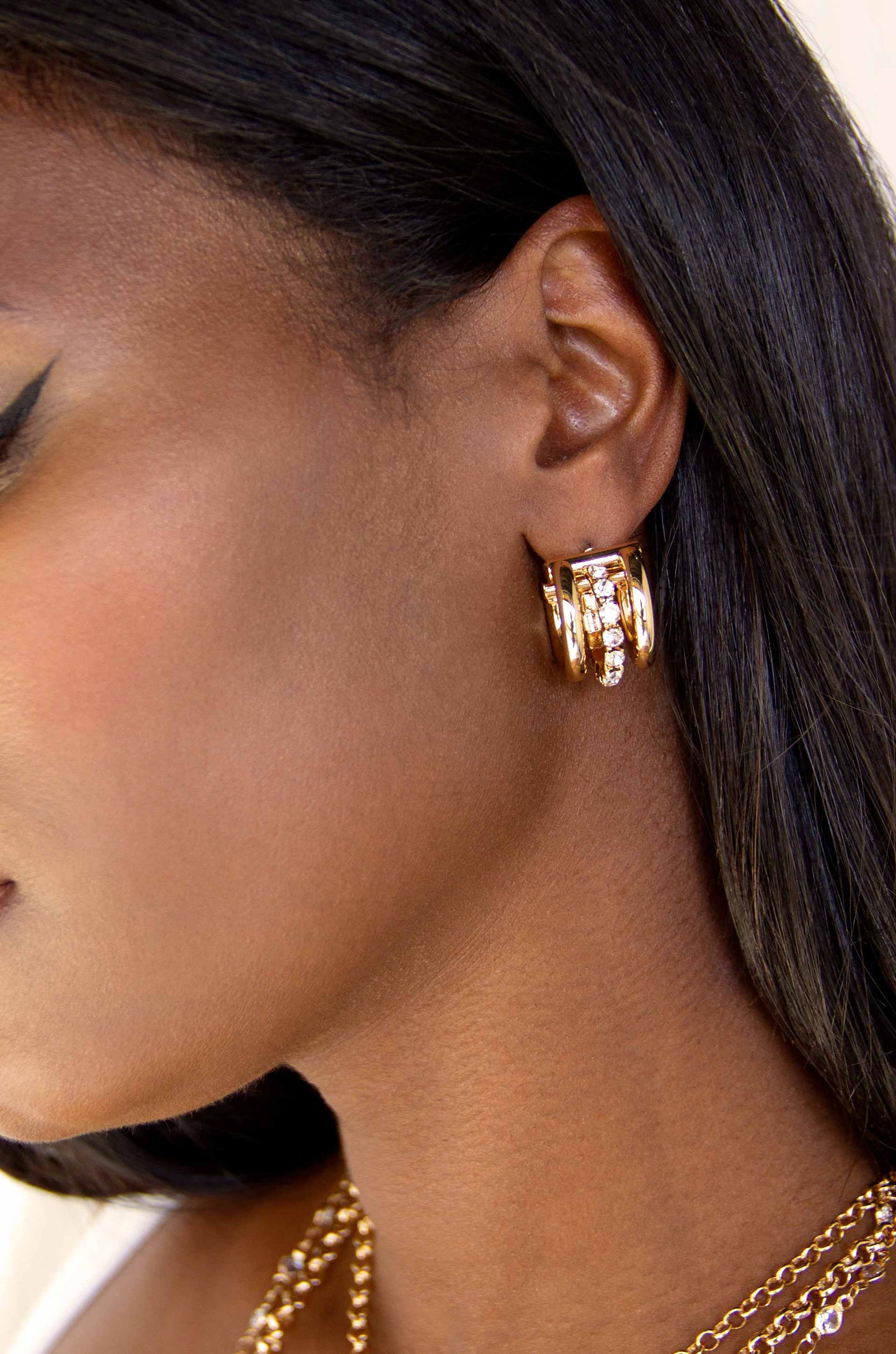 Thick Crystal Accent 18k Gold Plated Huggie Earrings on a model