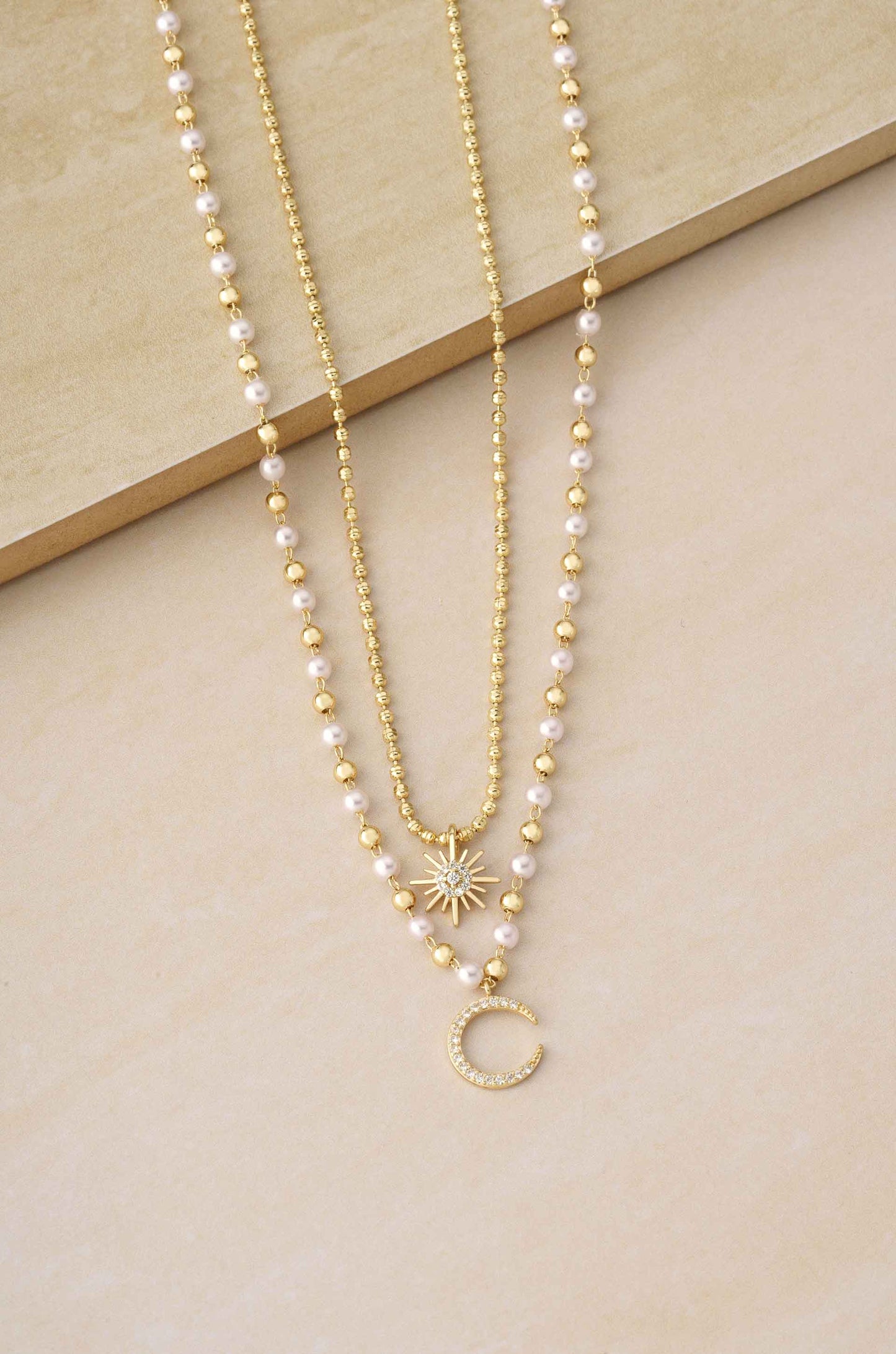 Interstellar Pearl and Crystal Layered 18k Gold Plated Necklace Set on slate background