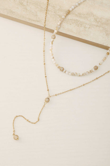 Shell Bead and Crystal Lariat 18k Gold Plated Necklace Set on slate background  