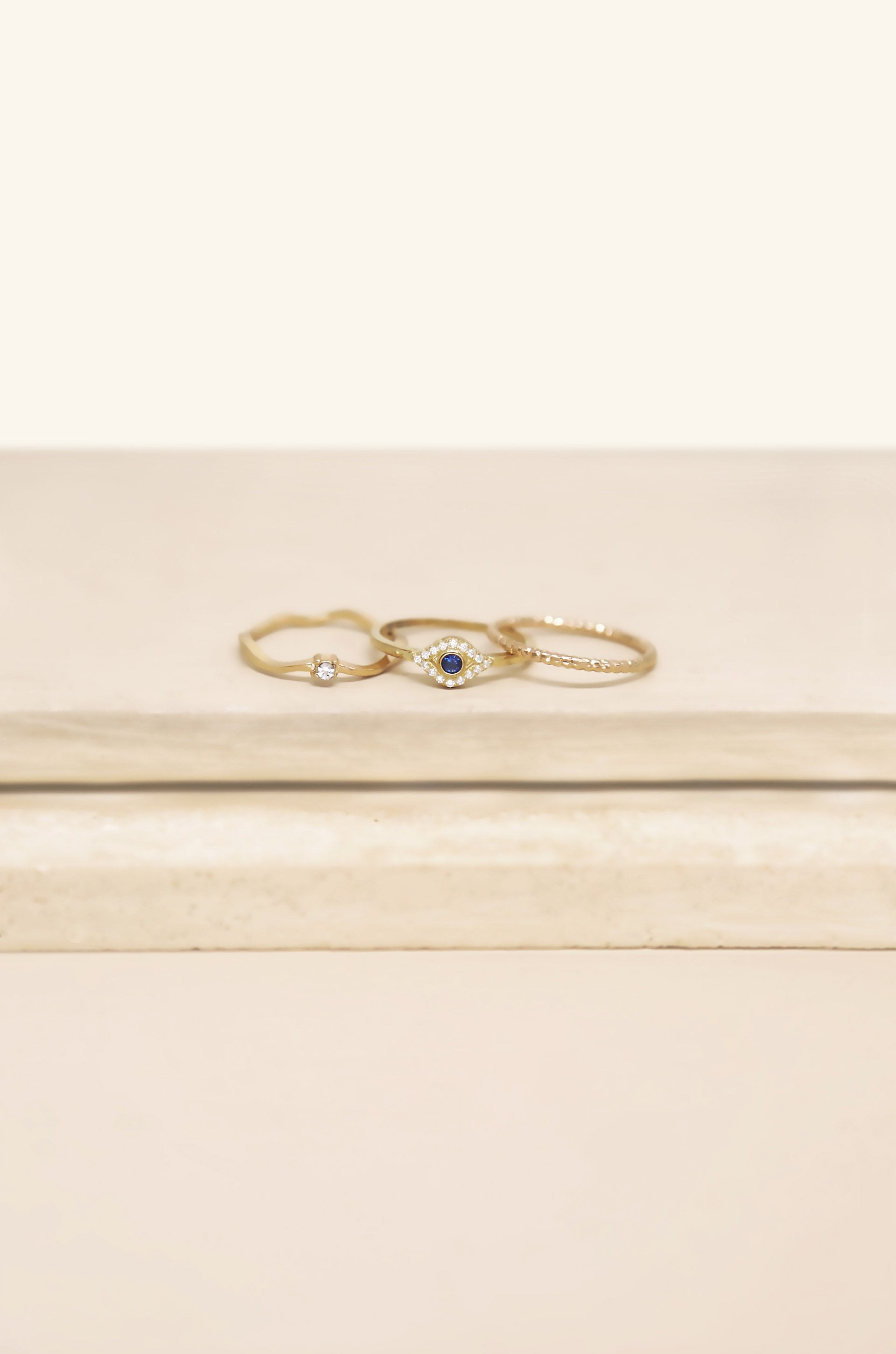 Dainty Crystal Trio 18k Gold Plated Ring Set on slate background  