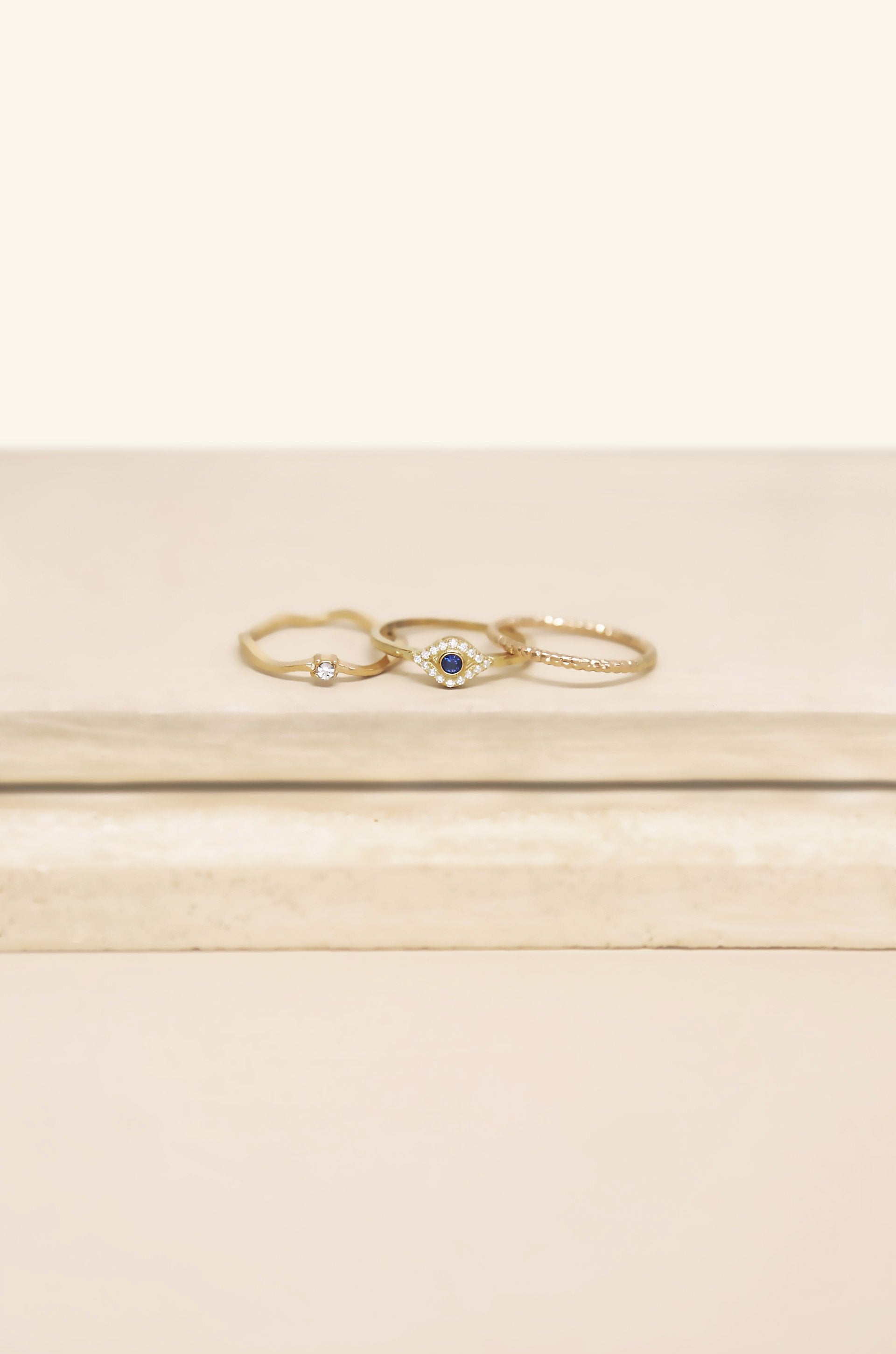 Dainty Crystal Trio 18k Gold Plated Ring Set on slate background  
